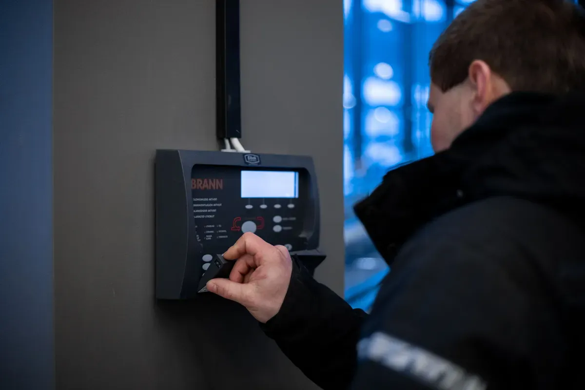 en person som trykker på en brannalarm sentral