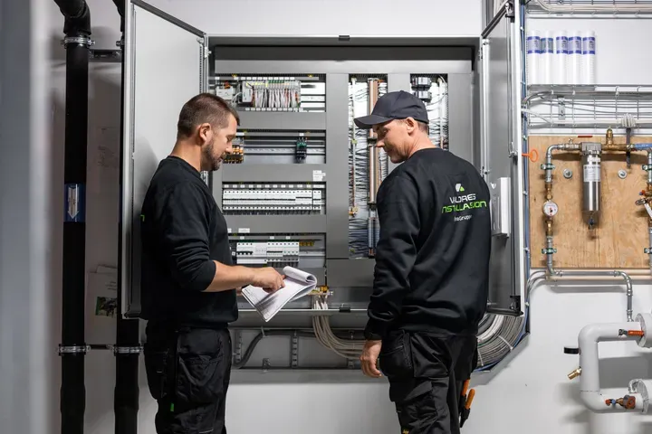 to Valdres Installasjons ansatte som jobber med et sikringsskap