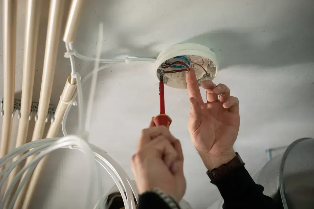 en person som installerer en røykealarm