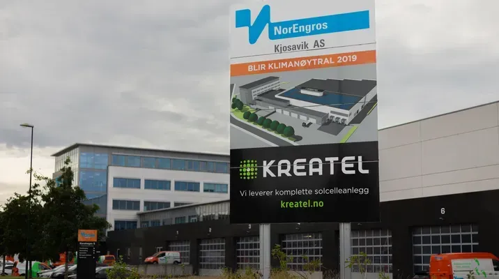 Skilt utenfor Norengros Kjosavik med Kreatel-reklame for komplette solcelleanlegg.