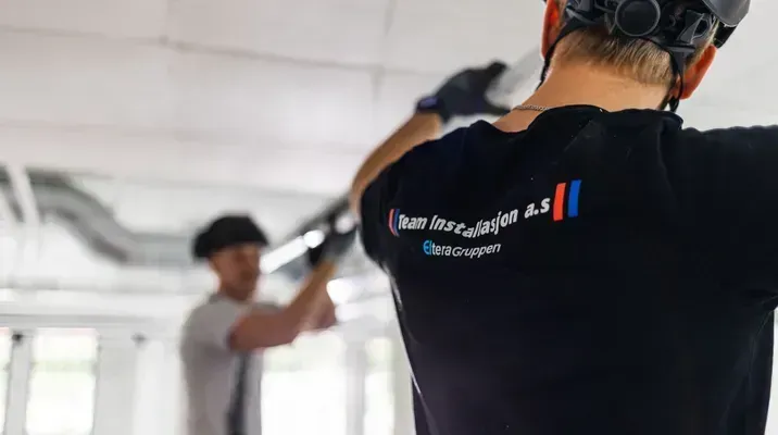 To elektrikere fra Team Installasjon arbeider med kabelføring i tak.
