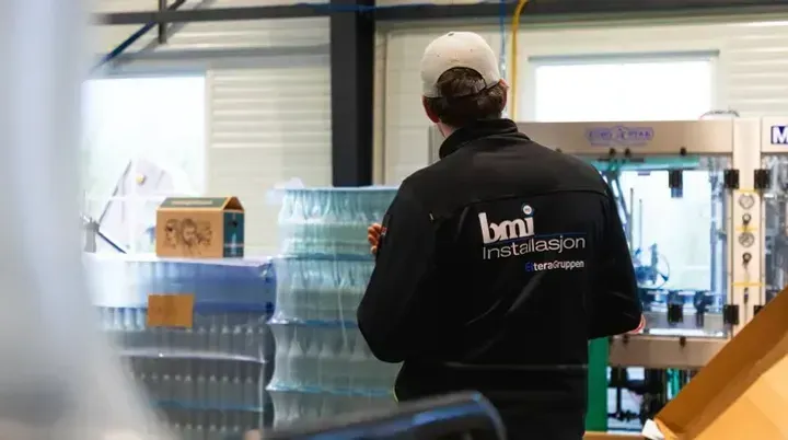 BMI-ansatt inspiserer produksjonslinje med flasker hos Hardangerbonden.