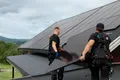 To elektrikere bærer solcellepanel.