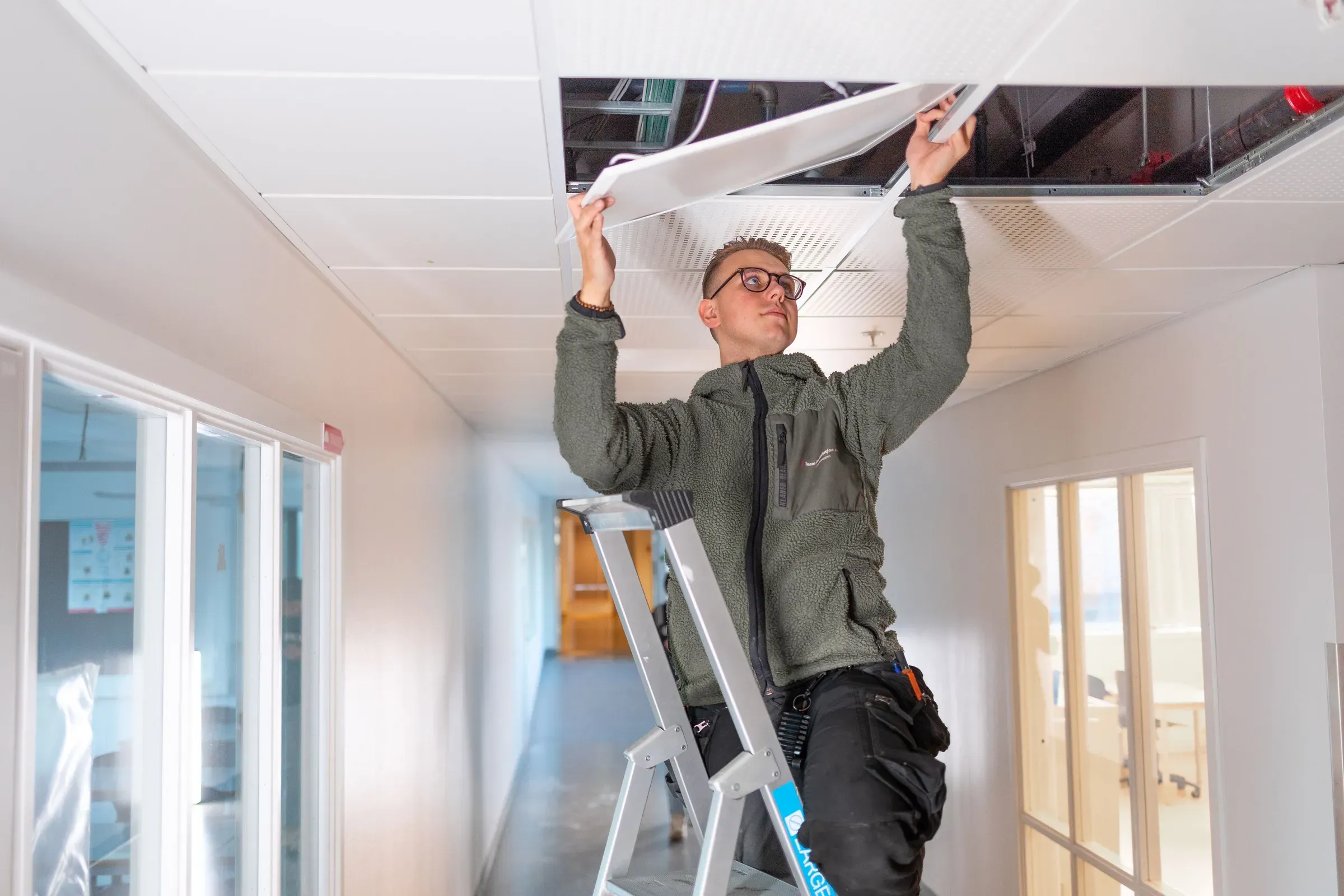 Elektriker i arbeid ved Kirkeparken vgs, der belysning er levert av Team Installasjon.