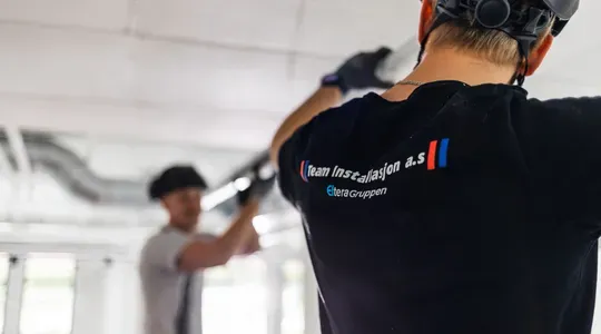 Elektriker i arbeid med belysning hos Rema 1000.