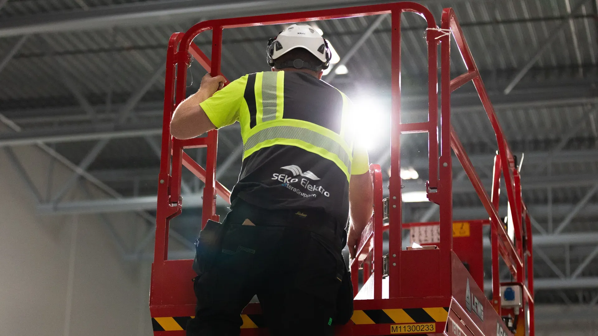 Elektriker fra SEKO Elektro på lift ved belysningsarbeid ved anlegget hos TOMRA Plastretur Recovery Facility (TPRF).