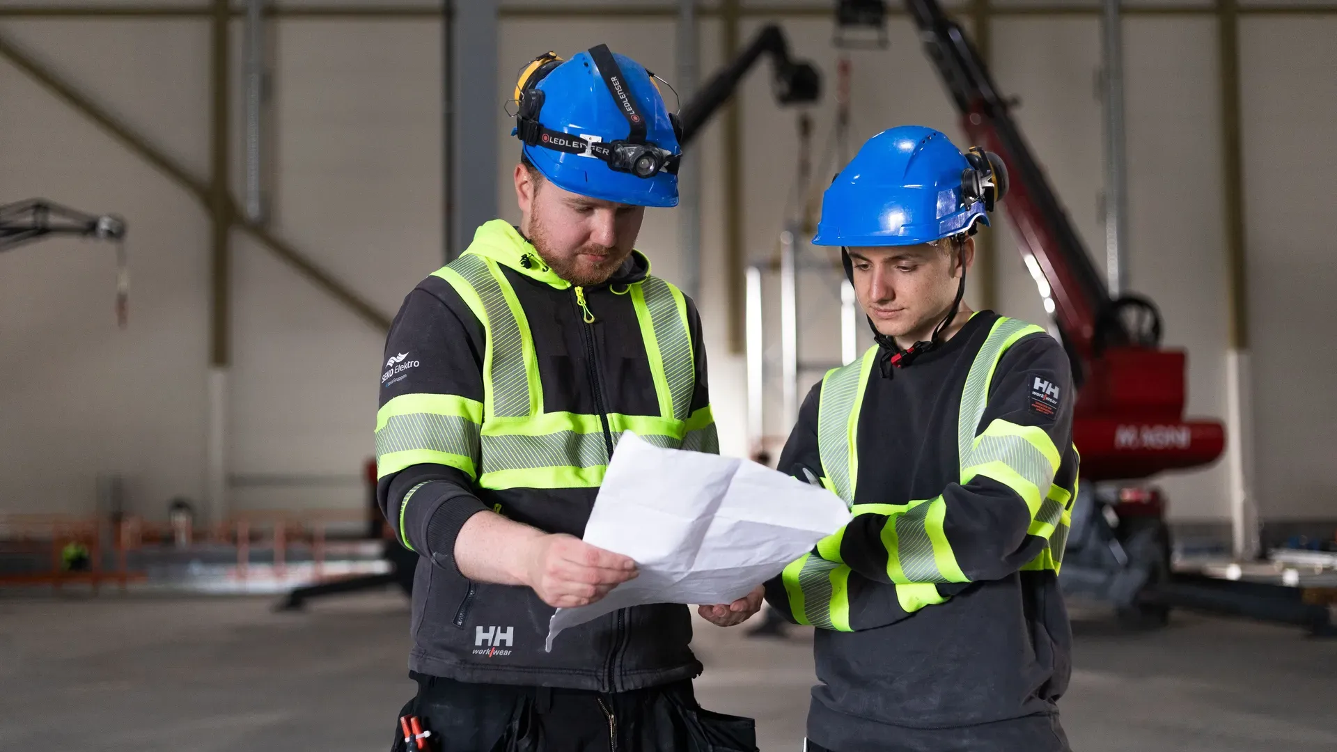 To elektrikere fra SEKO Elektro ser på plantegninger ved anlegget hos TOMRA Plastretur Recovery Facility (TPRF).