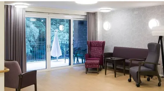 En stue med sofa, tre stoler og dør ut til en balkong