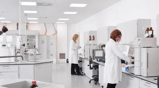 Et laboratorie med to personer i hvit frakk som arbeider