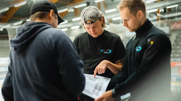 Tre elektrikere ser på plantegninger.