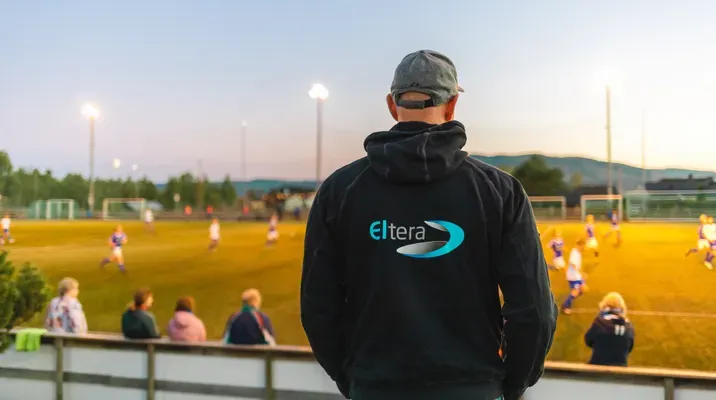 Eltera-elektriker ser på fotballbane med tribunelys.