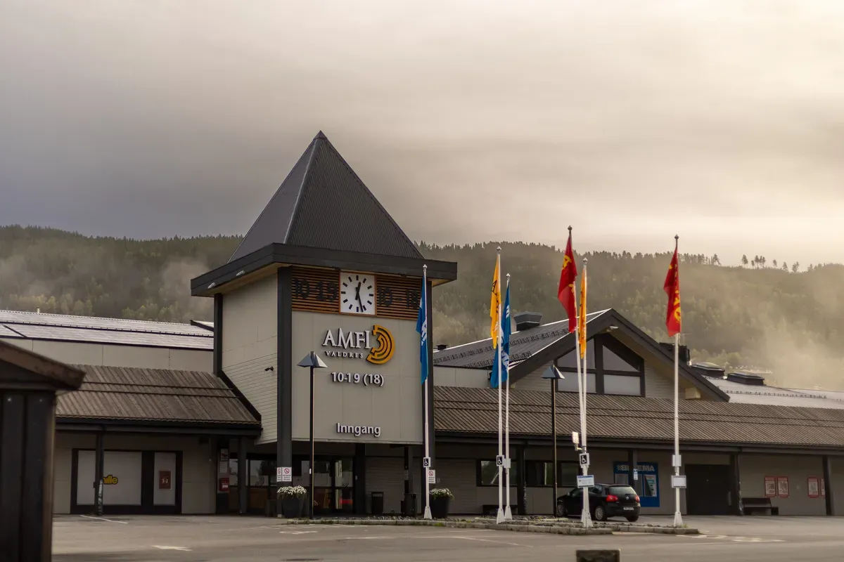 Fasade og inngangsparti for kjøpesenteret Amfi Valdres, vist fra parkeringsplassen