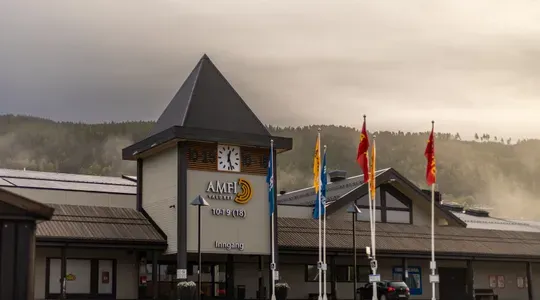 Fasade og inngangsparti for kjøpesenteret Amfi Valdres, vist fra parkeringsplassen