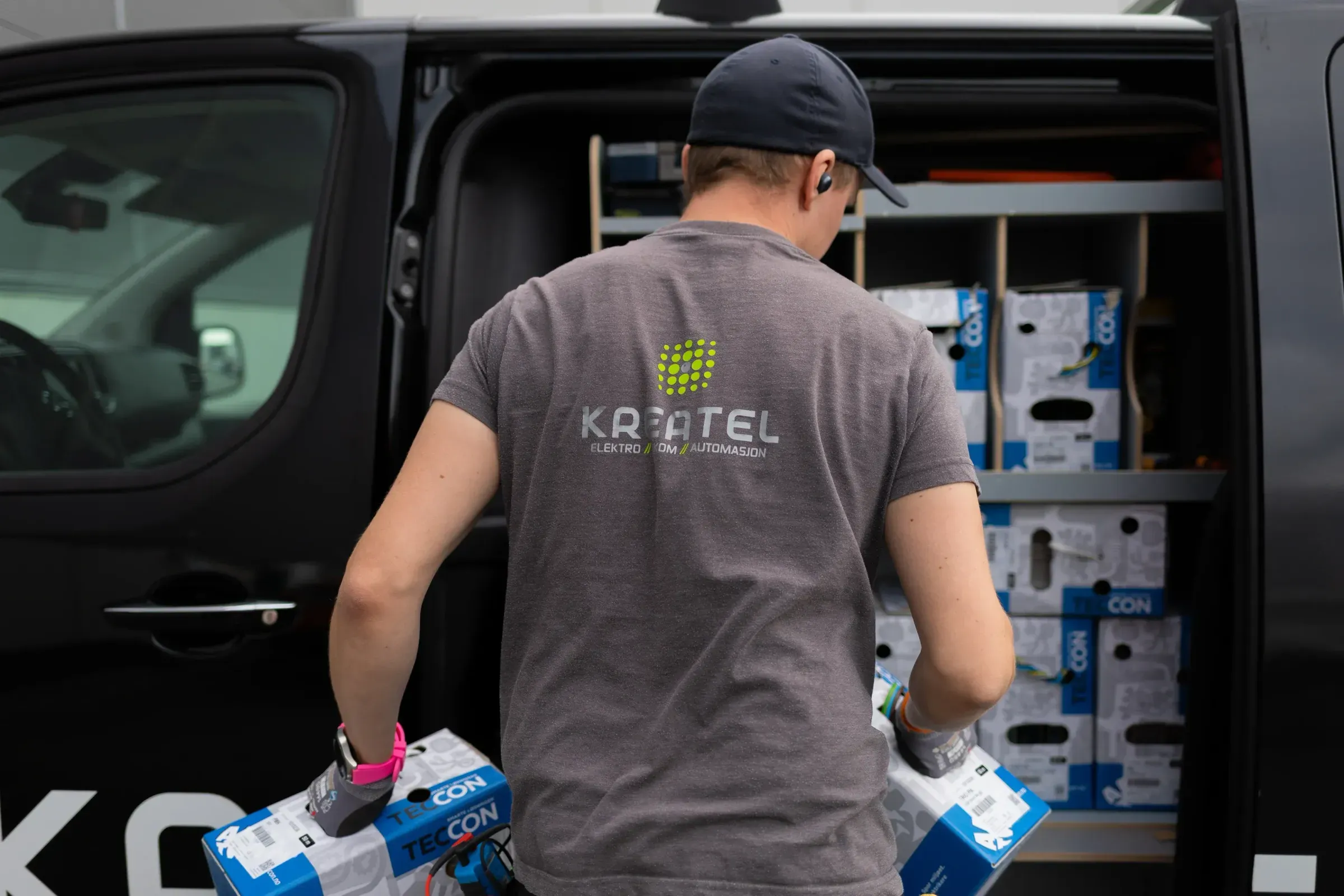 Elektriker fra Kreatel AS laster inn materiale i arbeidsbilen