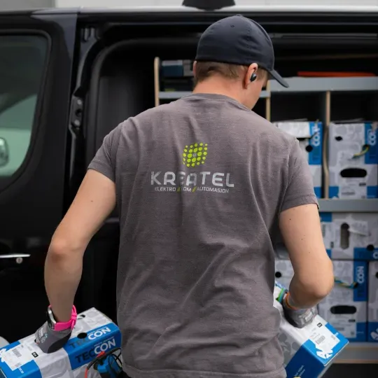 Elektriker fra Kreatel AS laster inn materiale i arbeidsbilen