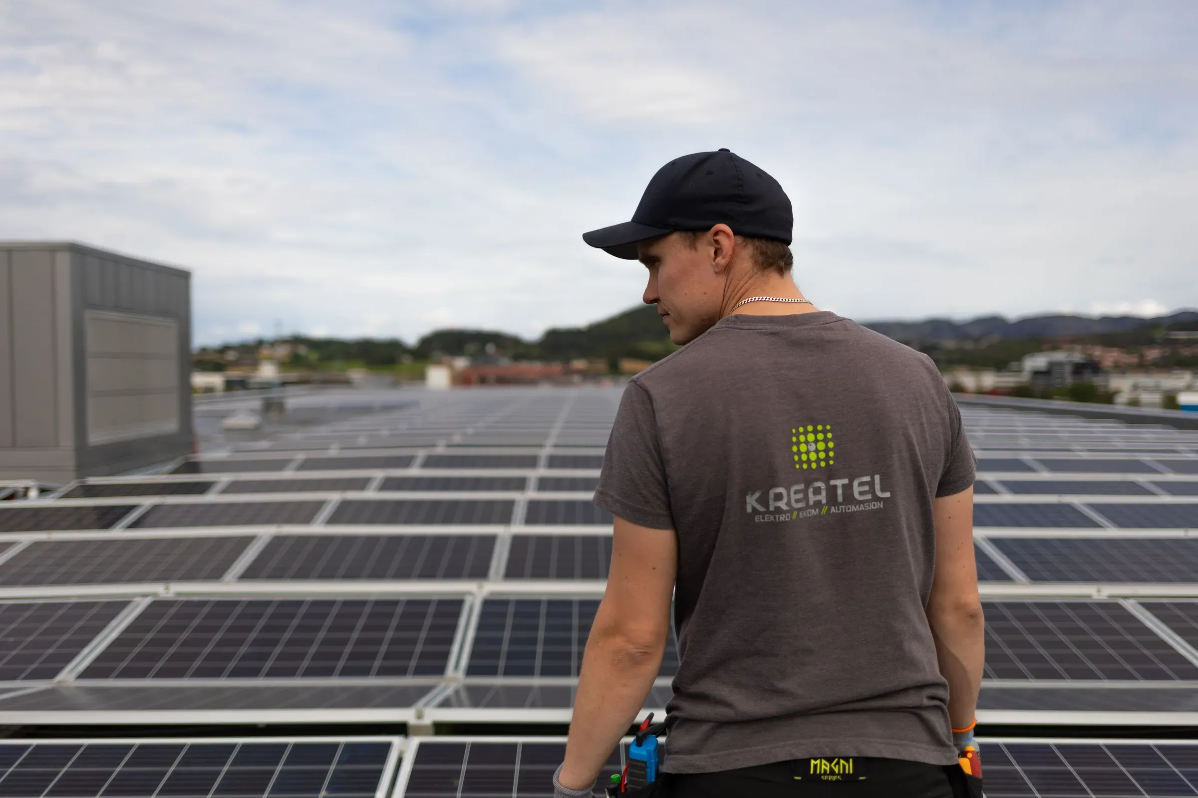 en kreatel ansatt som står foran solcelle paneler.