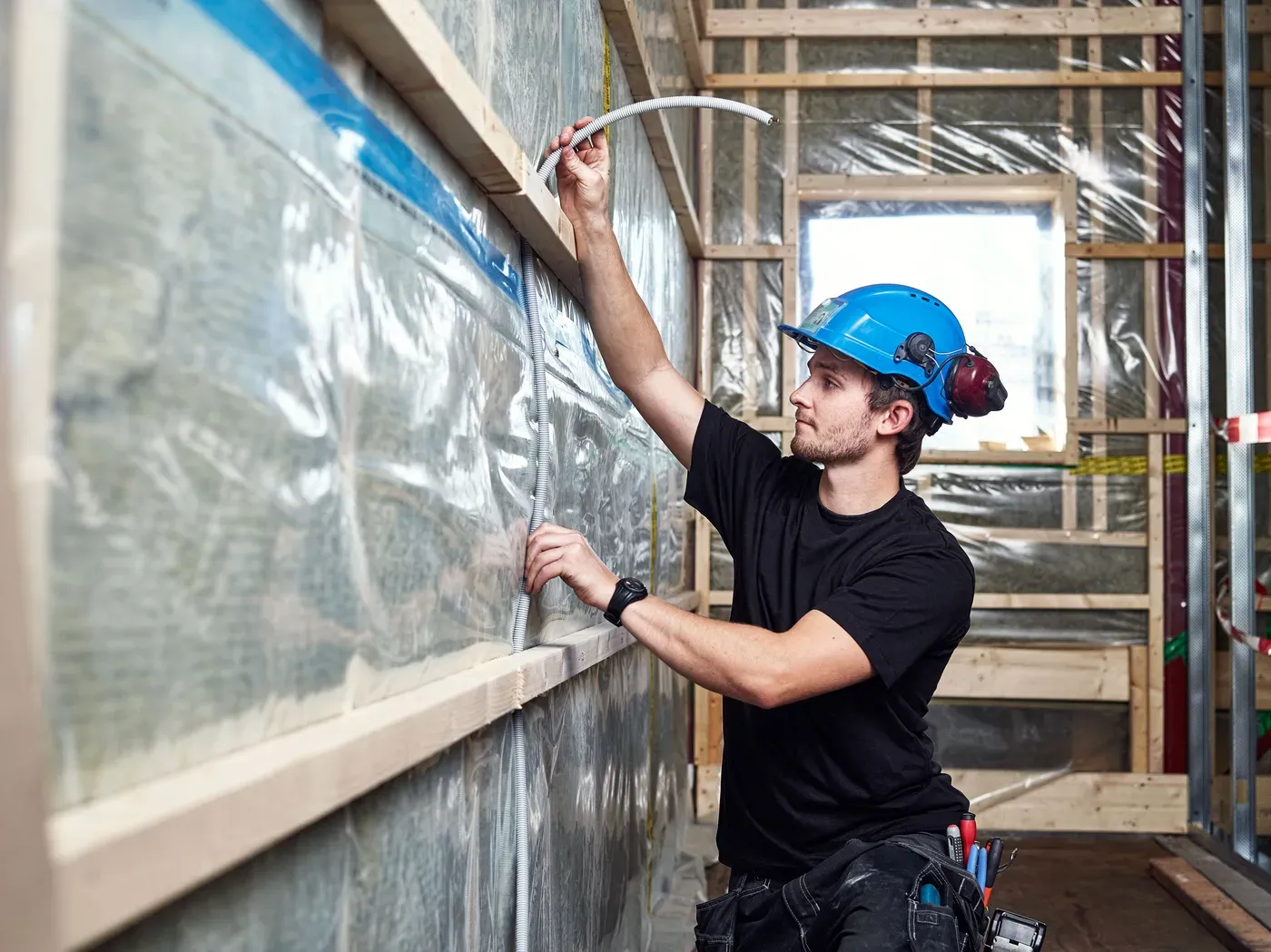Mann med hjelm som legger en kabel