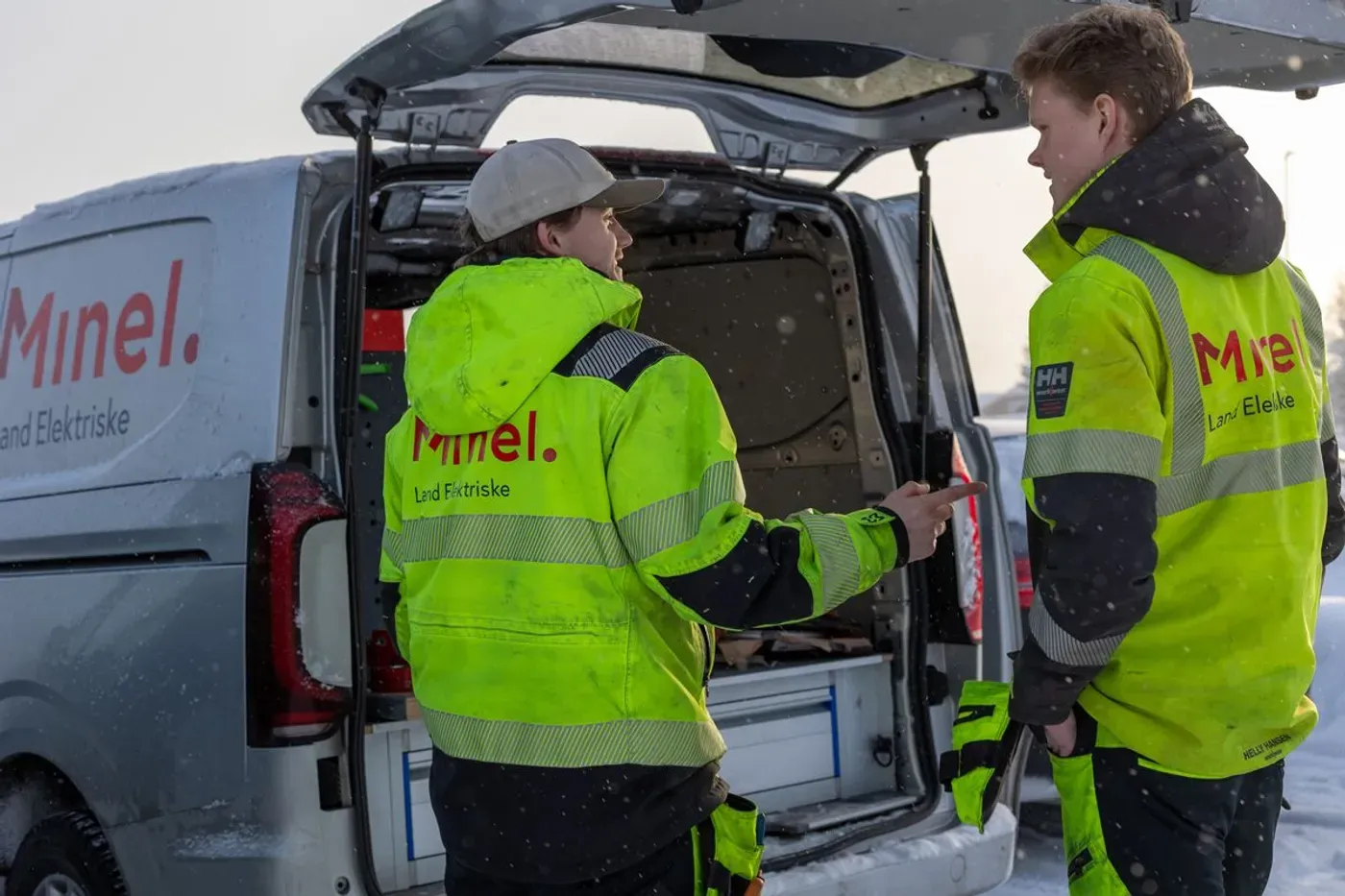 to elektrikere diskuterer utenfor servicebil