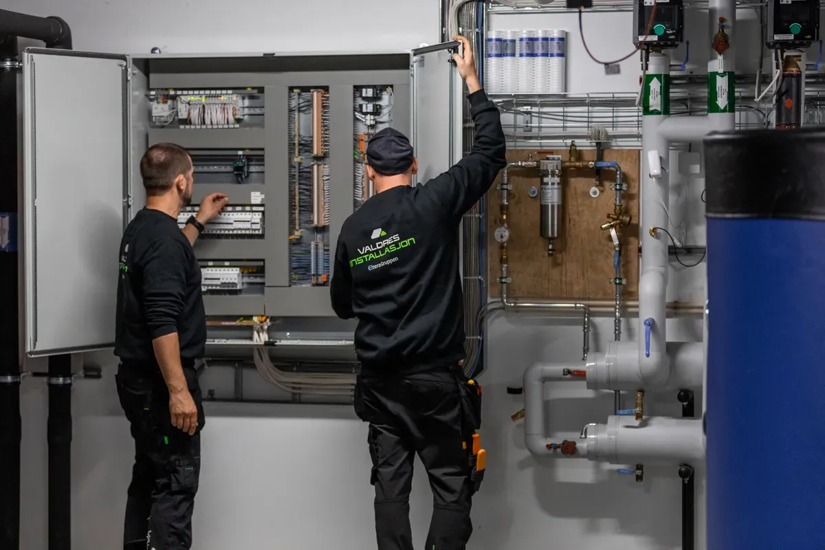 to Valdres Installasjons ansatte som jobber i et sikringsskap