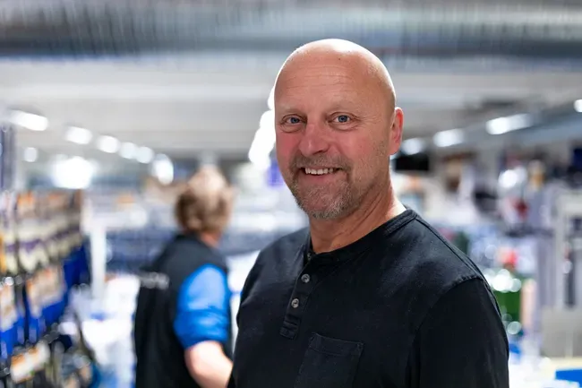 En smilende mann i en butikk
